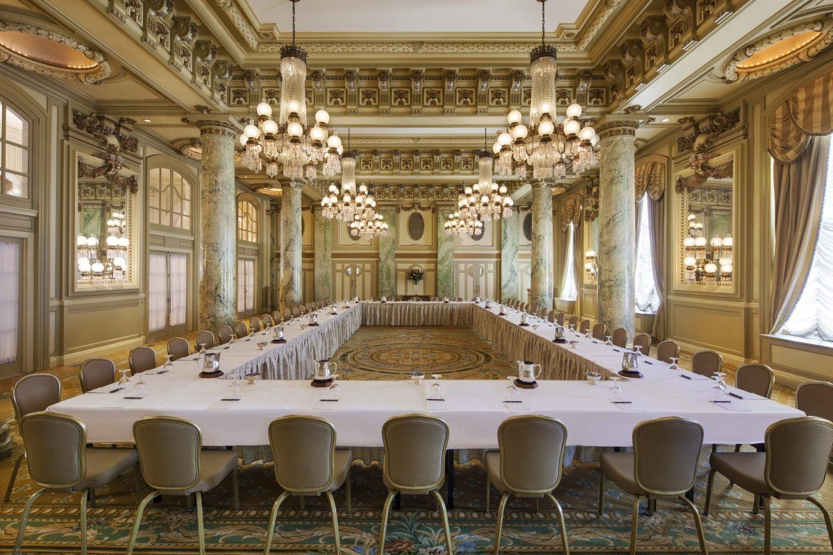 Grand hotel ballroom with chandeliers set for a board meeting