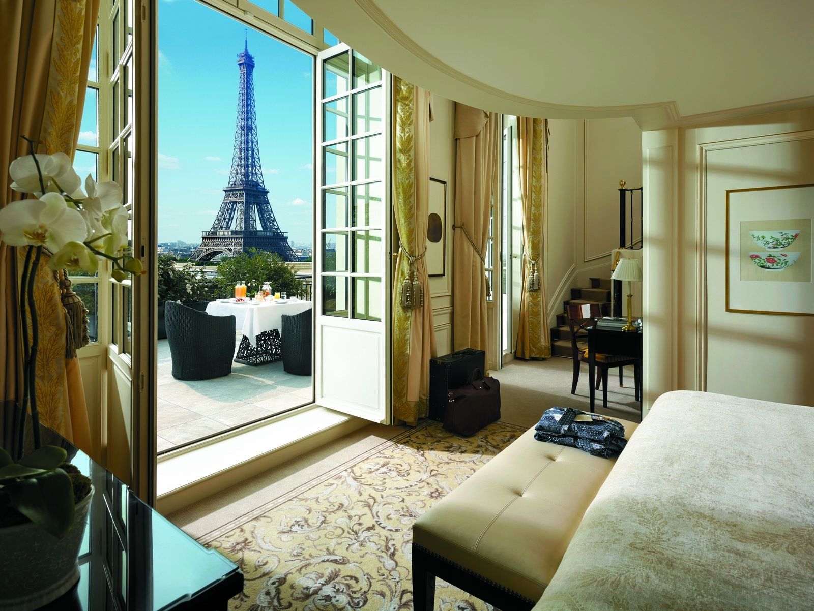 Hotel suite with balcony doors open toward the Eiffel Tower